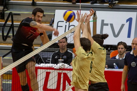 UNB's Eduardo Luchese takes aim at a pair of Sherbrooke blockers during Friday's 3-1 win. Luchese had 20 kills and 10 digs in his Reds debut. (Photo: James West/for UNB Athletics)
